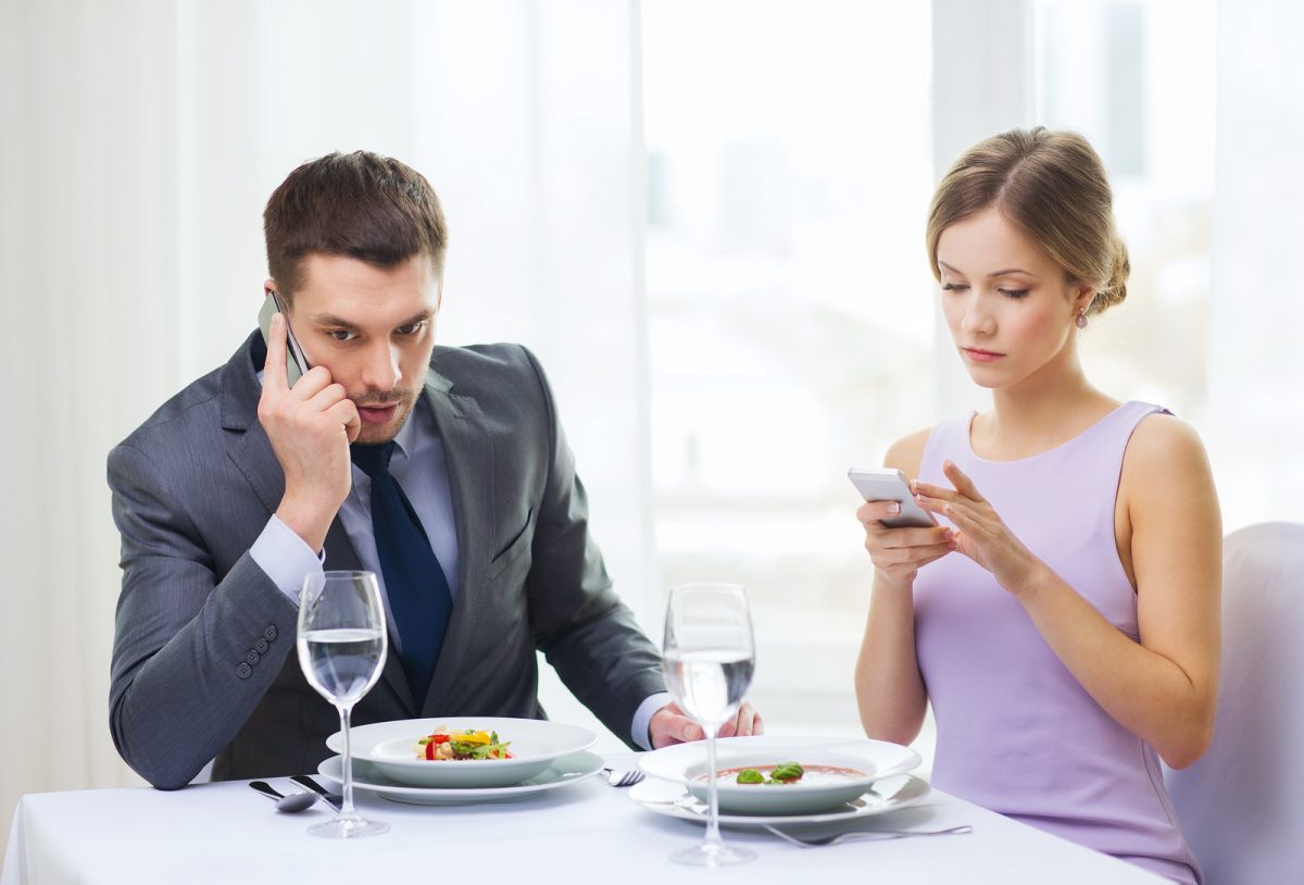Couple-on-cell-phones-during-date-1200x814