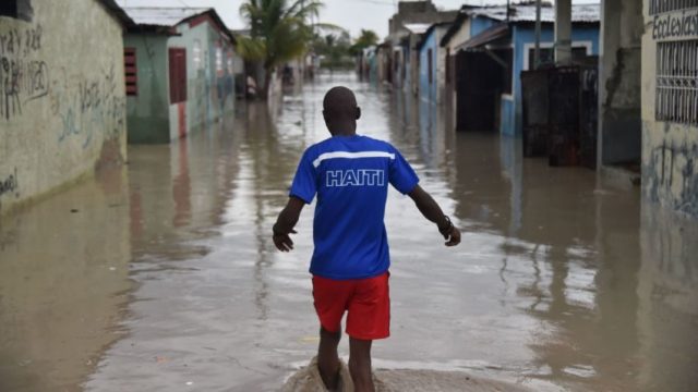 A man walks down a flooded street, in a neighbourhood of the commune of Cite Soleil, in the Haitian Capital Port-au-Prince, on October 4, 2016. Hurricane Matthew slammed into Haiti, triggering floods and forcing thousands to flee the path of a storm that has already claimed three lives in the poorest country in the Americas. / AFP PHOTO / HECTOR RETAMALHECTOR RETAMAL/AFP/Getty Images